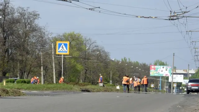 Працівники прибирають траву в Бахмуті