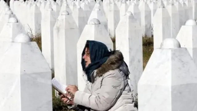 नरसंहार में मारे गए लोगों को याद करती एक महिला