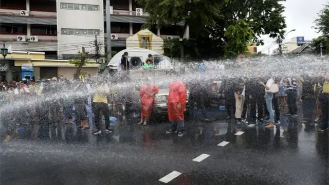 Police spray water as they clean the road stained with blue paint during a pro-democracy activists" protest against government and monarchy in Bangkok, Thailand October 13, 2020