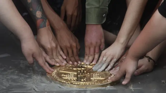 แกนนำร่วมกันแตะที่หมุดคณะราษฎรที่จัดทำโดยแนวร่วมธรรมศาสตร์และการชุมนุม