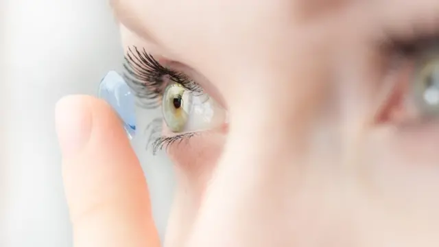 Una mujer se aplica una lente de contacto suave