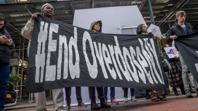 Manifestantes con un cartel que dice "Acaben con la sobredosis"