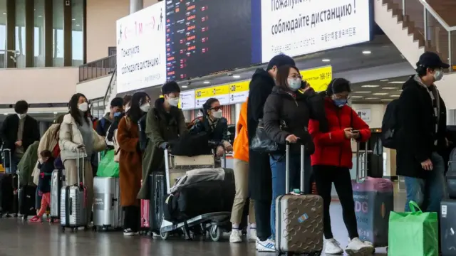 Pessoas com malas na fila no aeroporto