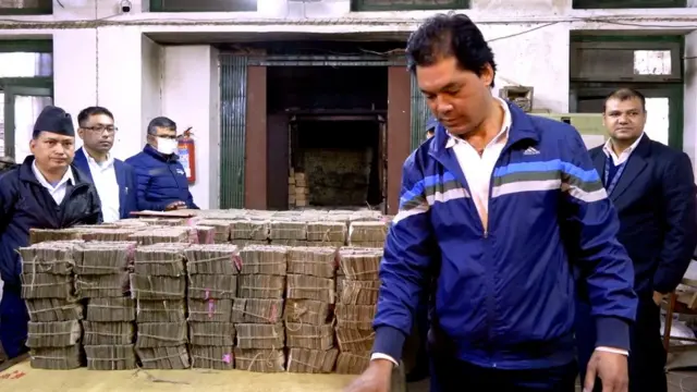 नष्ट गर्नुअघी नोट परिक्षण गर्दै कर्मचारी