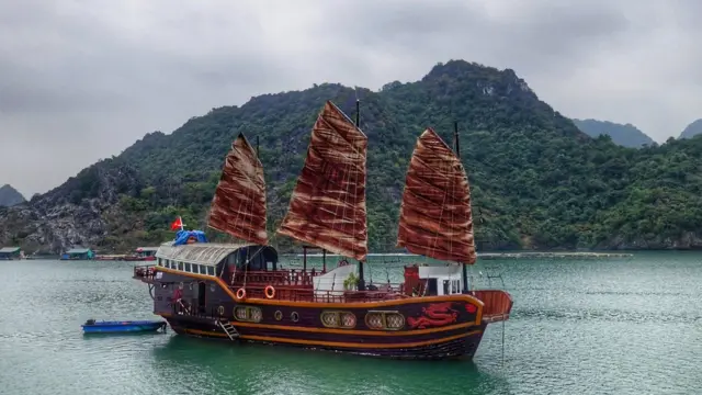 Navio chinês no mar, com serra atrás