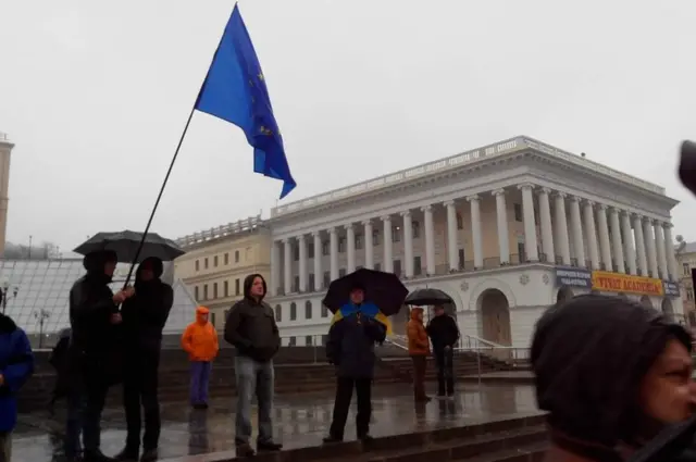 Кілька людей на майдані з пропором ЄС