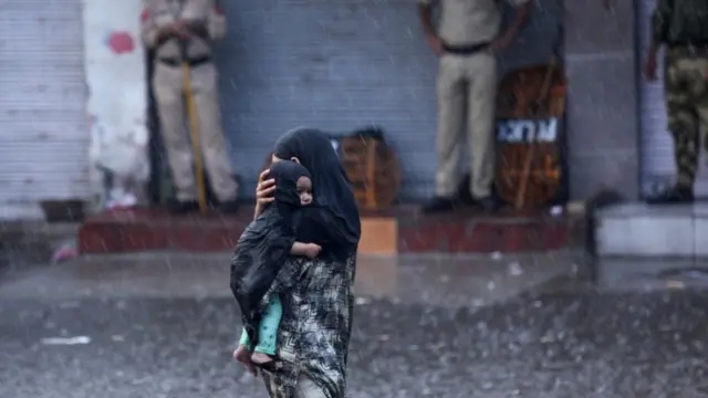 जम्मू में बारिश के दौरान महिला