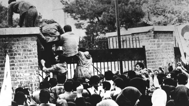 İranlı öğrenciler ABD Büyükelçiliğinin duvarınan tırmanırken, 4 Kasım 1979