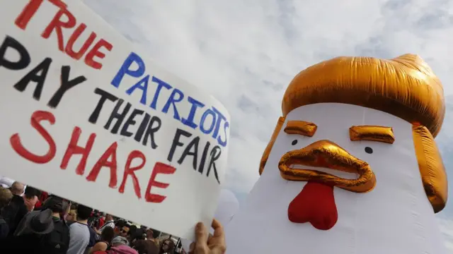 示威者高举一只代表特朗普的鸡型吹气玩偶。