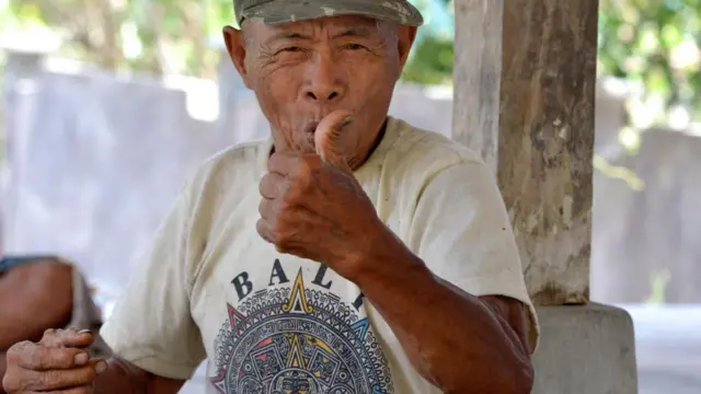 Imagem mostra homemdicas de apostas para hojevila na Indonésia se comunicando pela linguagemdicas de apostas para hojesinais chamada Kata Kolok