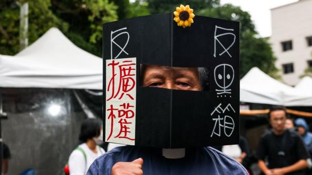 A protestor wears a box which symbolizes anti-black box and against power expanding during the vote for the Parliament reform bill outside of Legislative Yuan in Taipei on May 28, 2024. (Photo by I-Hwa CHENG / AFP) (Photo by I-HWA CHENG/AFP via Getty Images)