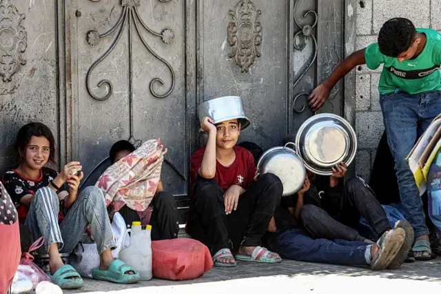 ينتظر نازحون فلسطينيون، بينهم عدد كبير من الأطفال، في طوابير طويلة للحصول على وجبات ساخنة توزعها منظمة خيرية في مدينة غزة، قطاع غزة، فلسطين، في 7 يونيو/حزيران 2026.