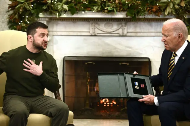 Zelensky entrega a Biden una condecoración militar.
