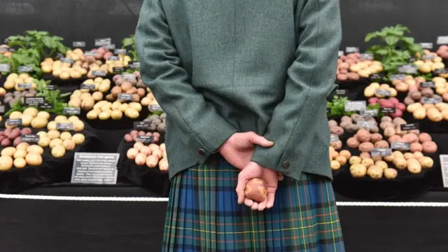 Мужчина с картошкой в руке