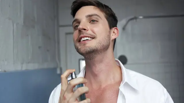 Hombre perfumándose