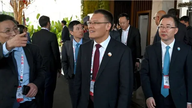 बैठक से बाहर आते हुए चीन के उप वित्त मंत्री डॉन्गवेई वांग