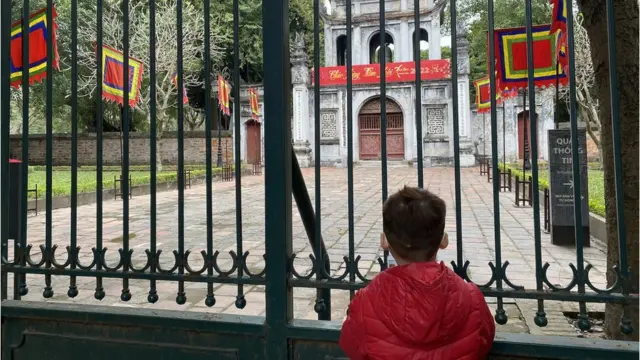 Đền Ngọc Sơn chỉ mở cửa đón từng tốp 10 người đi lễ mỗi lượt nên khá nhiều người phải đợi bên ngoài.