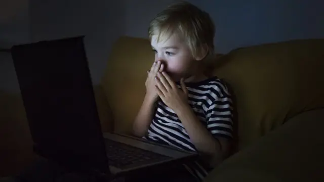 کودکی در حال نگاه کردن به صفحه لپ تاپ