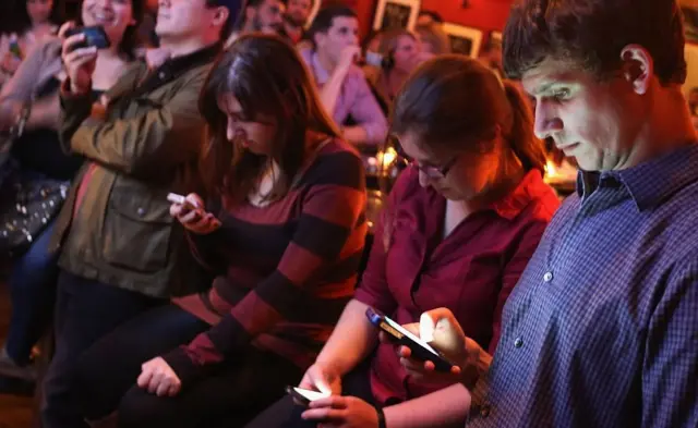 Gente usando su celular