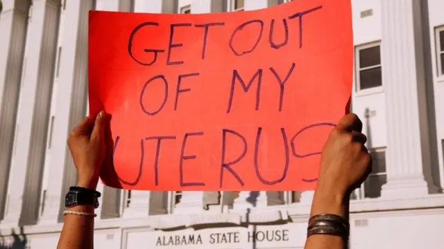 Cartel en inglés que dice: "Fuera de mi útero"