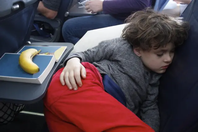항공기 좌석에서 몸을 웅크리고 잠든 아이