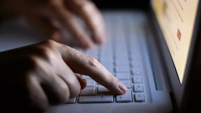 अपने लैपटॉप पर कार करती एक महिला.