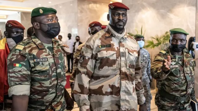 Le président du Comité national pour le rassemblement et le développement (CNRD), le colonel Mamady Doumbouya (C), quitte une réunion avec des représentants de haut niveau de la Communauté économique des États de l'Afrique de l'Ouest (CEDEAO) à Conakry, le 17 septembre 2021