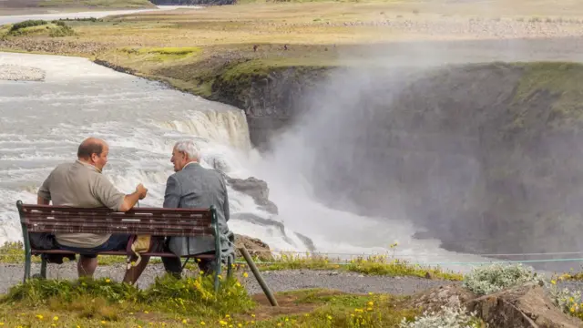 Dos hombres conversando en un banco de Islandia.