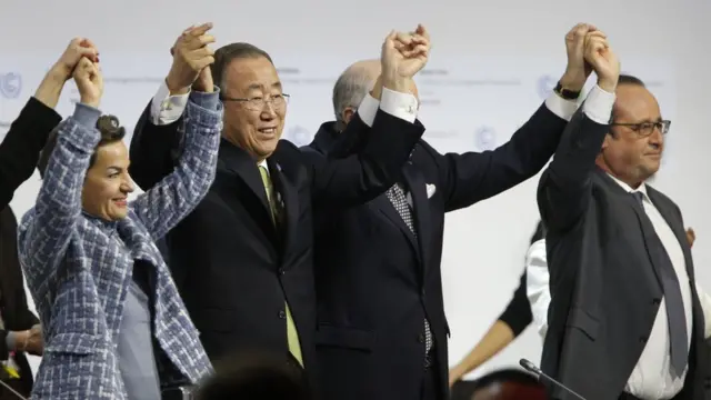 People dey hold hands as dem sign climate agreement for Paris for 2015