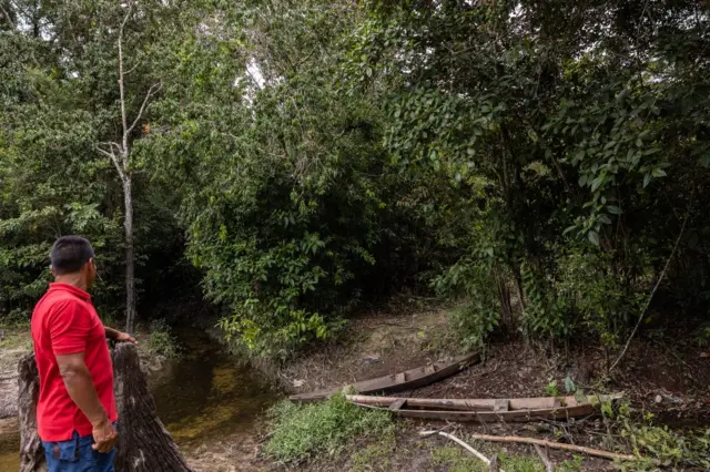 Orlando Rufino olha para barcos no terreno arenoso onde estaria o rio