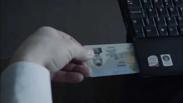 Hombre insertando su tarjeta de identidad digital en su laptop