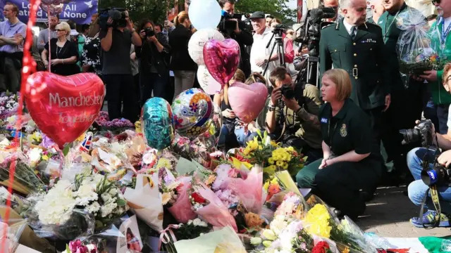 Manchester'da hayatını kaybedenleri anmak için olay yerine çiçekler bırakılıyor.
