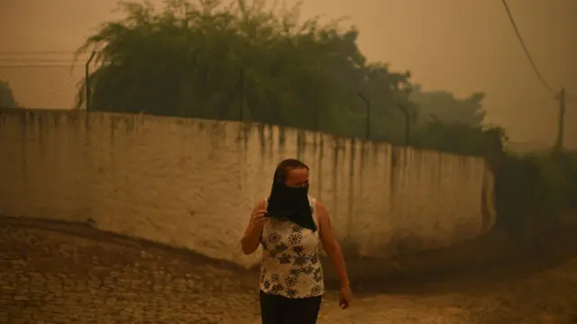 Una mujer se cubre la boca y la nariz para protegerse del humo en la aldea de Torgal, Castanheira de Pera, el 18 de junio de 2017.
