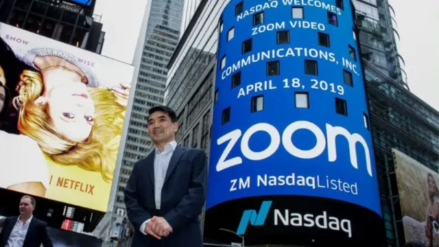 Le fondateur de Zoom, Eric Yuan, pose devant le bâtiment du Nasdaq à New York- un écran geant affiche le logo de la société de logiciels de vidéoconférence
