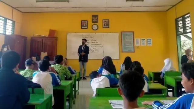 Ilustrasi mahasiswa KKN sedang memberikan edukasi pada siswa SMP.