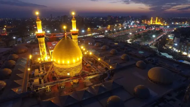 صورة جوية ليلية لمرقد الإمام العباس وفي الخلفية يبدو مرقد الإمام الحسين وسط مدينة كربلاء العراقية