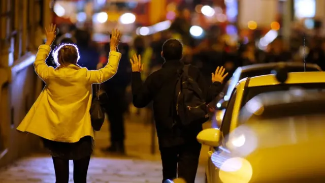 Transeúntes alzan las manos