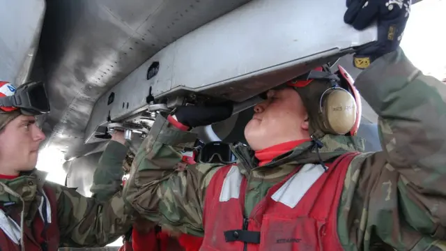 أرشيف: جنود البحرية الأمريكية يعملون على إحكام تركيب فوهة إطلاق القذيفة على متن ناقلة تحمل سبعة طائرات في ولايو أوريغون عام 2014.