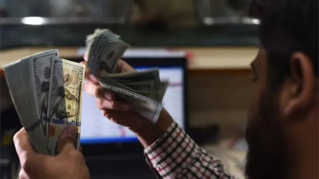 پاکستانی شخص ڈالرز کی گنتی کرتے ہوئے