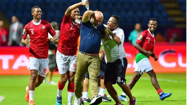 Abakinnyi ba Madagascar bishimira intsinzi kuri Nigeria basuka amazi ku mutoza wabo Nicolas Dupuis