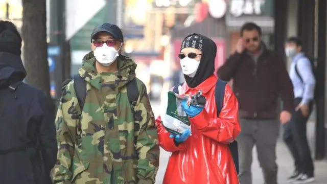 নিউ ইয়র্ক শহরের রাস্তায় মাস্ক পরা কয়েকজন