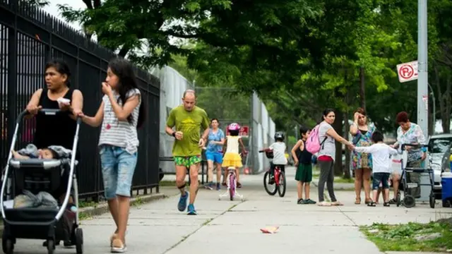 Un competidor y peatones en la acera