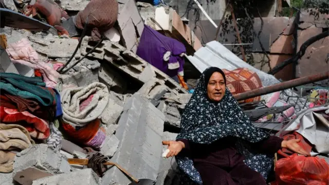 امرأة تشير إلى الأنقاض في أعقاب الغارات الإسرائيلية في شمال غزة