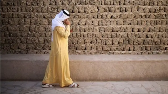 مواطن خليجي يمسك هاتفه