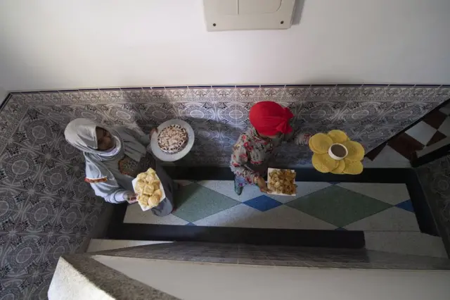 Des membres d'une famille marocaine portent des plats pour une fête marquant l'Aïd Al-Fitr chez eux au milieu du confinement des coronavirus à Rabat, au Maroc, le 24 mai 2020.