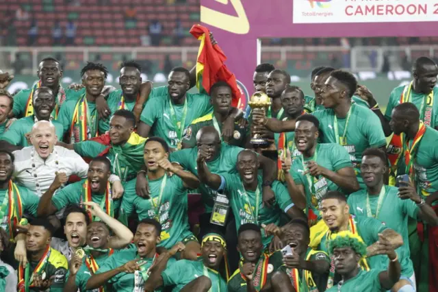 Les joueurs du Sénégal, brandissant le trophée, célèbrent leur victoire en finale de la Coupe d'Afrique des Nations (CAN) 2021 face à l'Égypte au Stade d'Olembe de Yaoundé, au Cameroun, le 6 février 2022.
