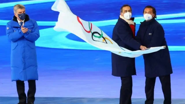 Mayor of Milano city Guiseppe Sala and Mayor of Cortina d" Ampezzo City Gianpetro Ghedina wave the Olympic flag next to International Olympic Committee (IOC) President Thomas Bach during the closing ceremony. REUTERS/Fabrizio Bensch