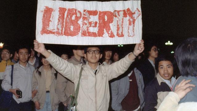 1989年4月22日，北京学生在天安门广场展示标语。
