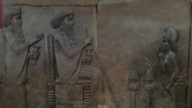 Барельефы, царь на троне, за ним стоит наследник, перед ними - полководец