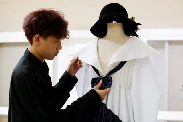 ติณห์ ตันโสภณ กำลังจัดชุดที่เขาออกแบบ